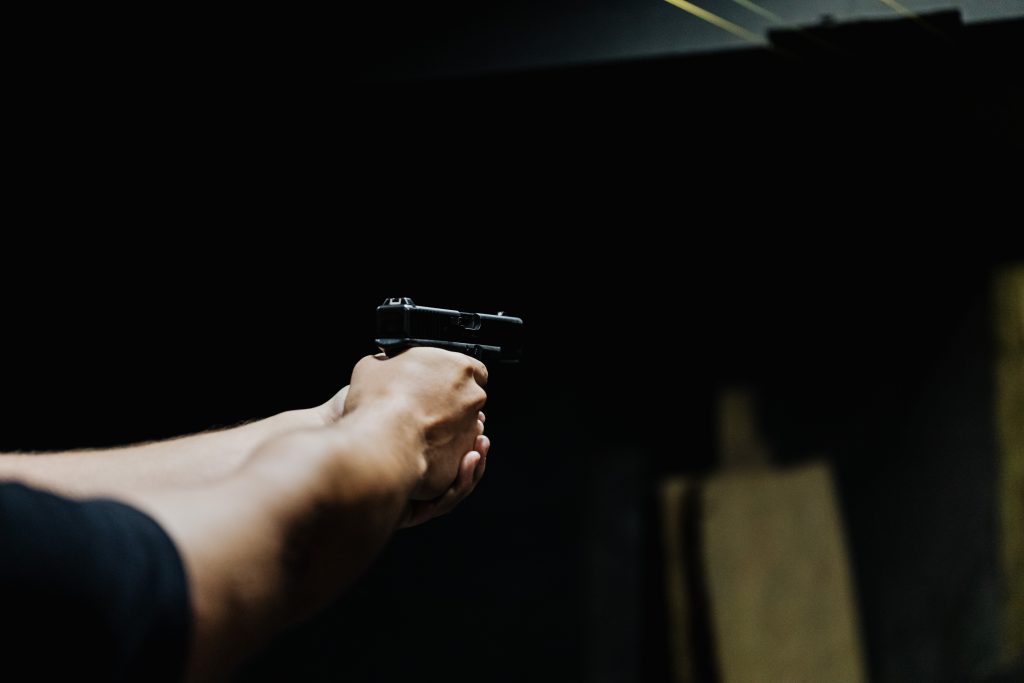 Hand mit einer Waffe, Sicherheitssimulation oder Sicherheitsausbildung.