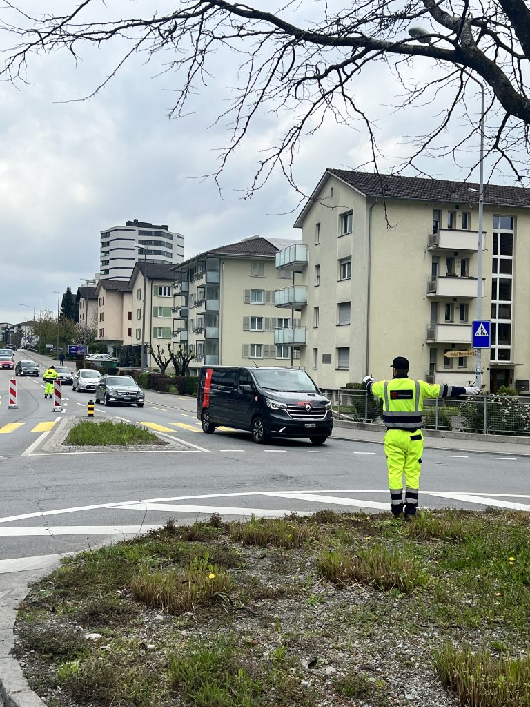 Verkehrsdienstmitarbeiter regelt den Verkehr an einem Kreisverkehr in Luzern, Schweiz.